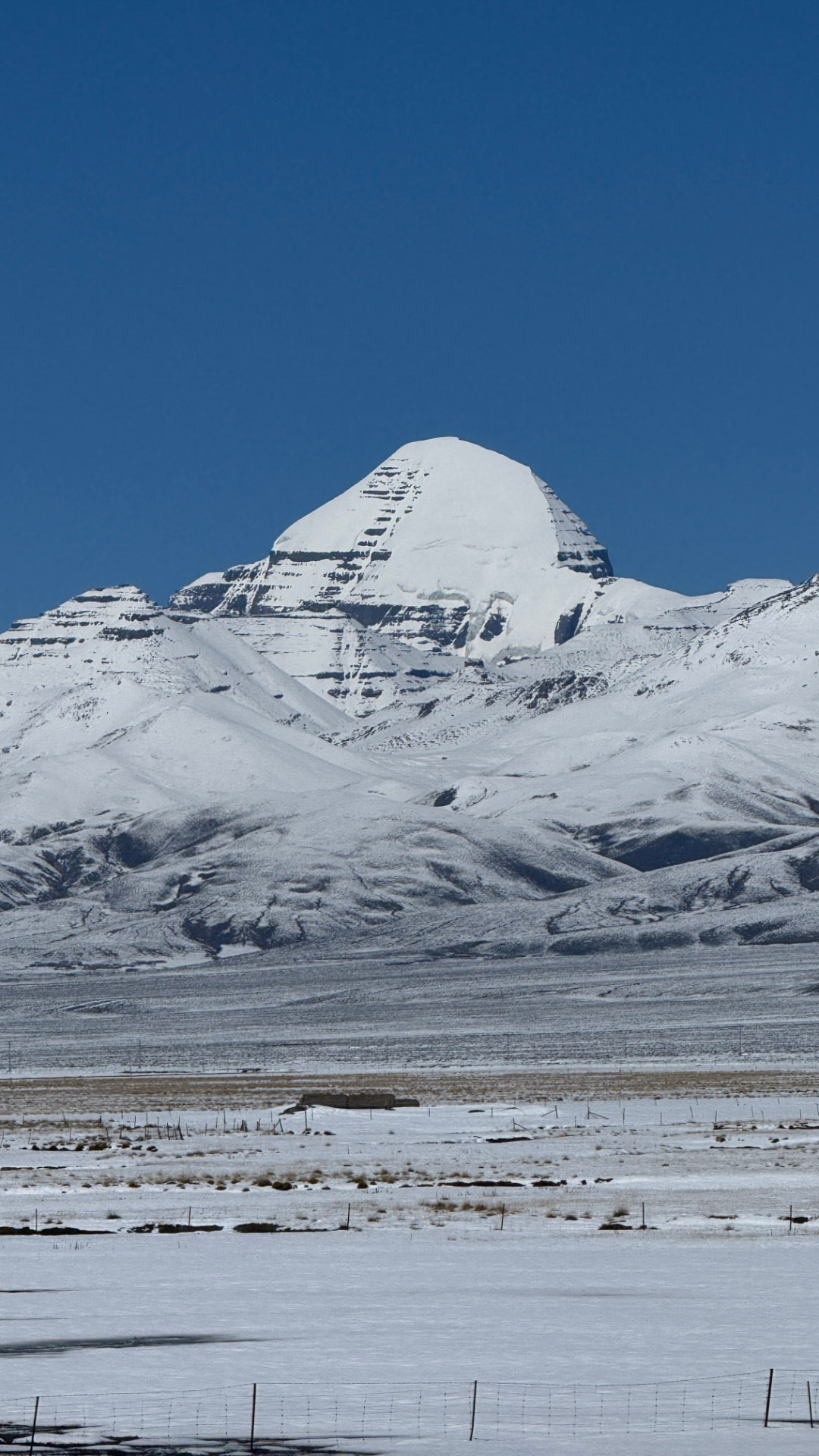 Mount Kailash framed vertically above the snowy Tibetan plateau