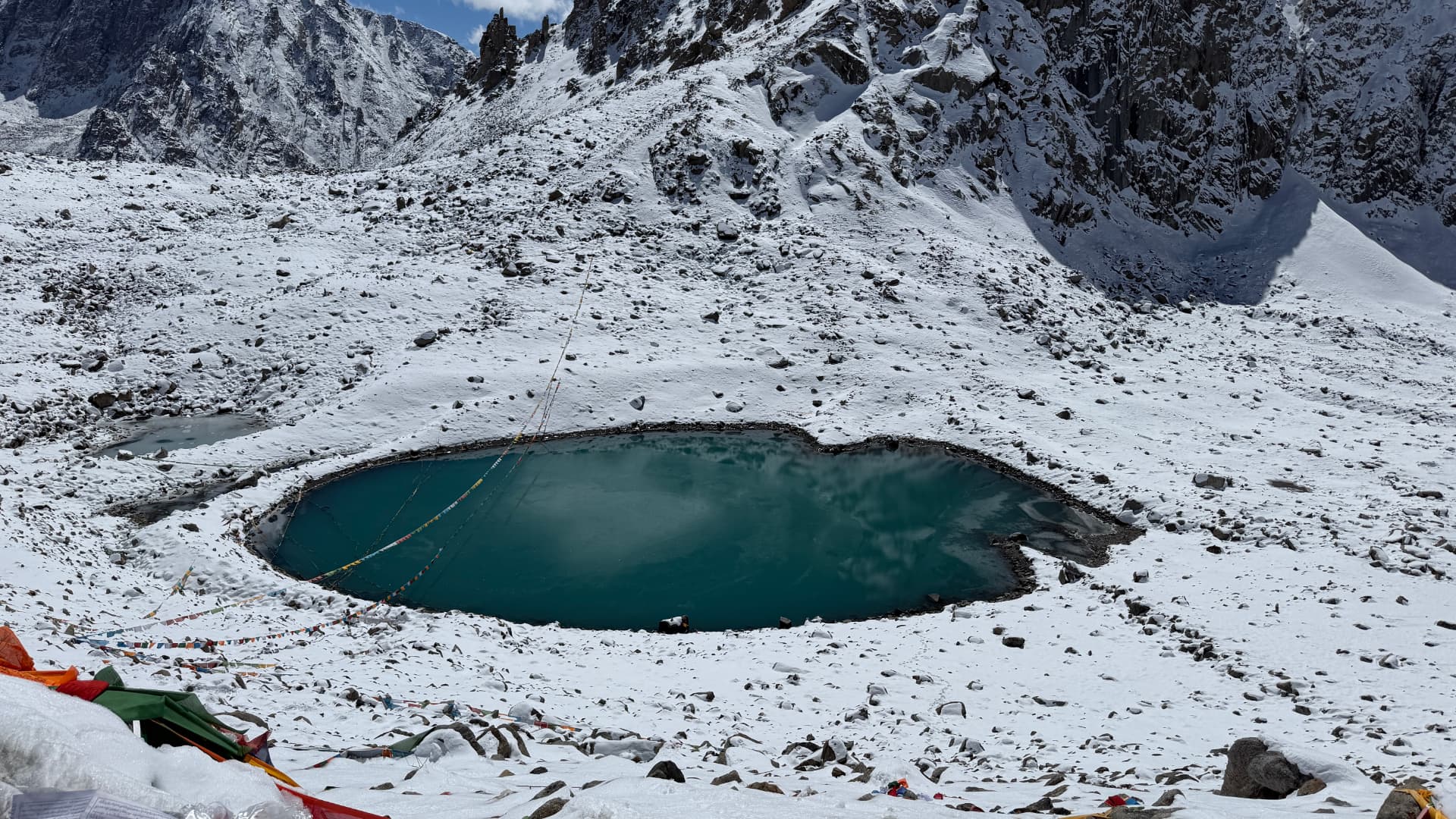 Gauri Kund's turquoise water surrounded by deep snow below Dolma La